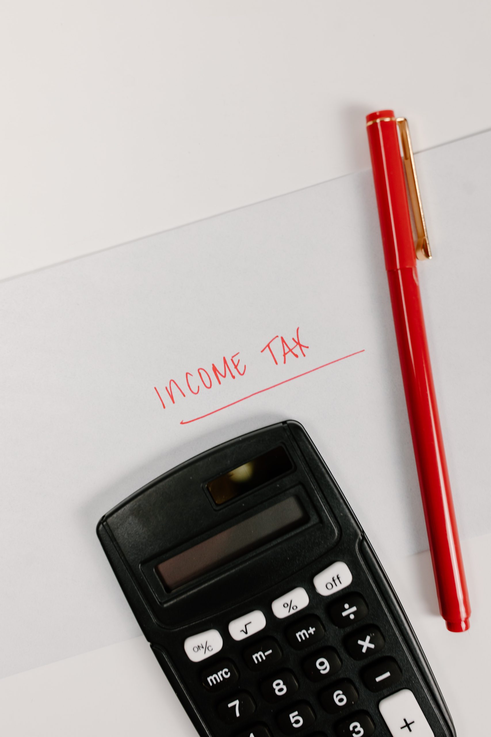 In the picture, there is a pen, Calculator and work income tax
